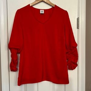 CAbi orange red V neck shirt with ruched sleeves.